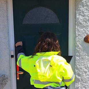 Volunteer knocking on a door