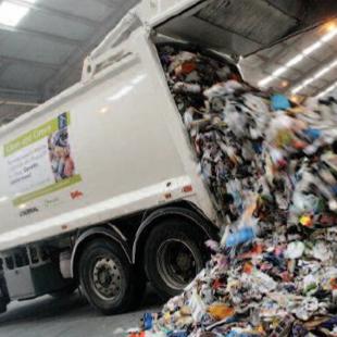 Waste truck tipping rubbish from trailer